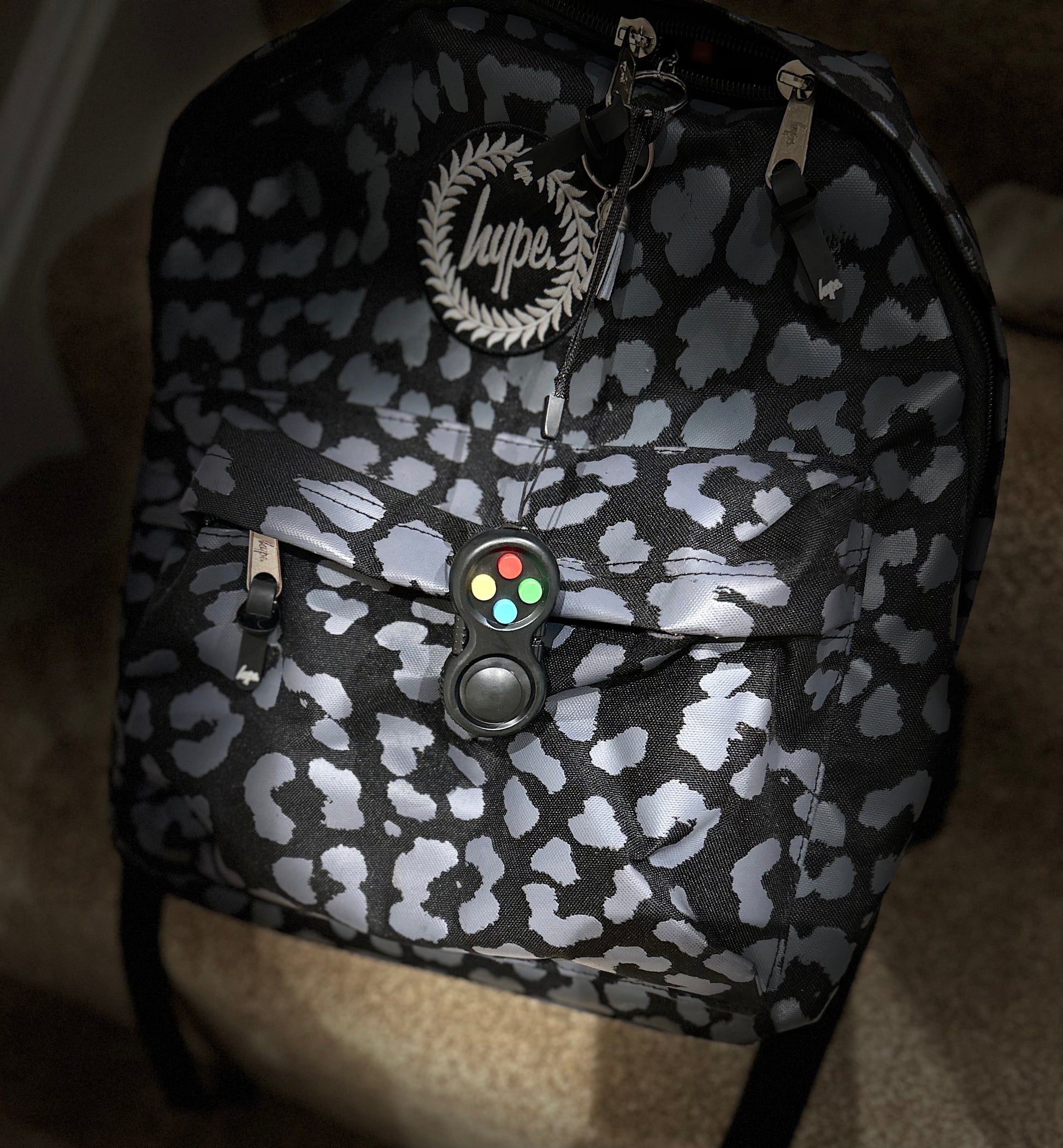 black fidget pad with coloured buttons on rucksack