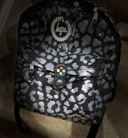 black fidget pad with coloured buttons on rucksack